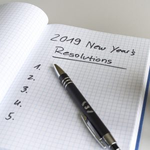 A notepad with a list of new year's resolutions for 2019 written with blank spaces.